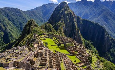 Aerial view of Machu Picchu surrounded by lush green mountains
