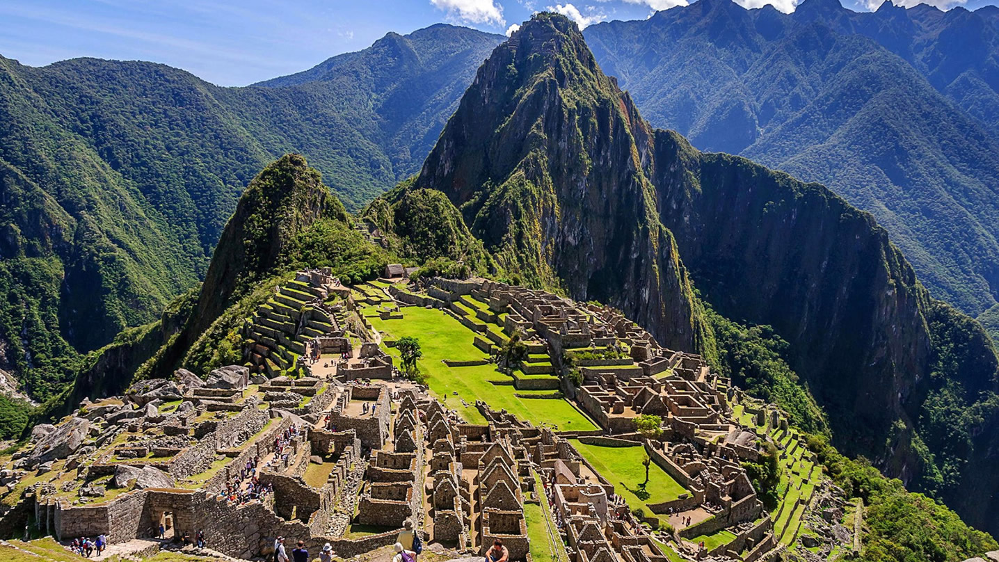 Aerial view of Machu Picchu surrounded by lush green mountains