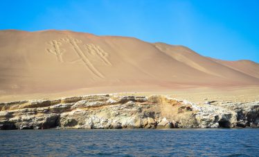 The Paracas Candelabro, a massive geoglyph etched into a sandy hill overlooking the Pacific Ocean in Peru.