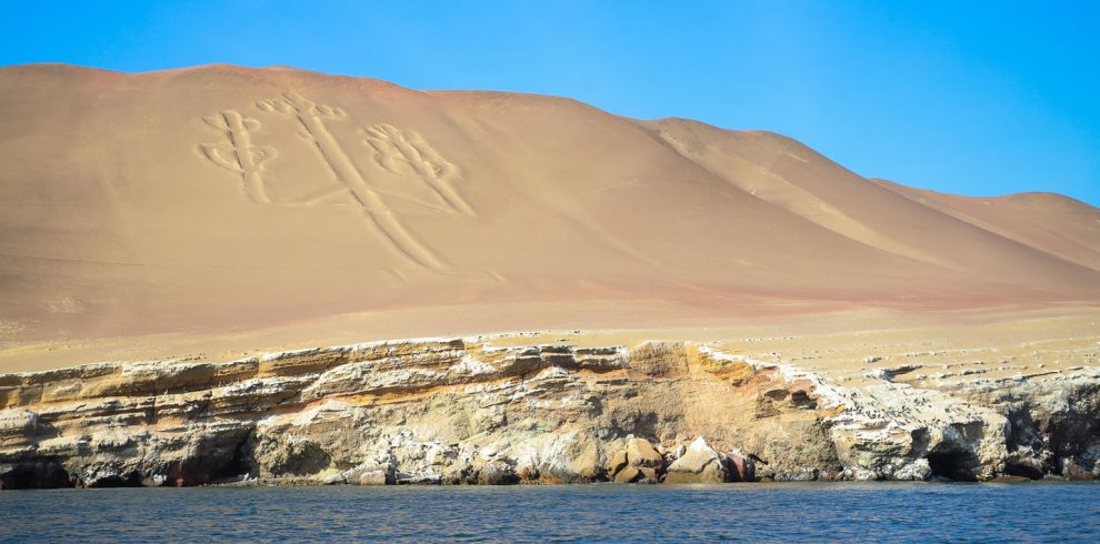 The Paracas Candelabro, a massive geoglyph etched into a sandy hill overlooking the Pacific Ocean in Peru.