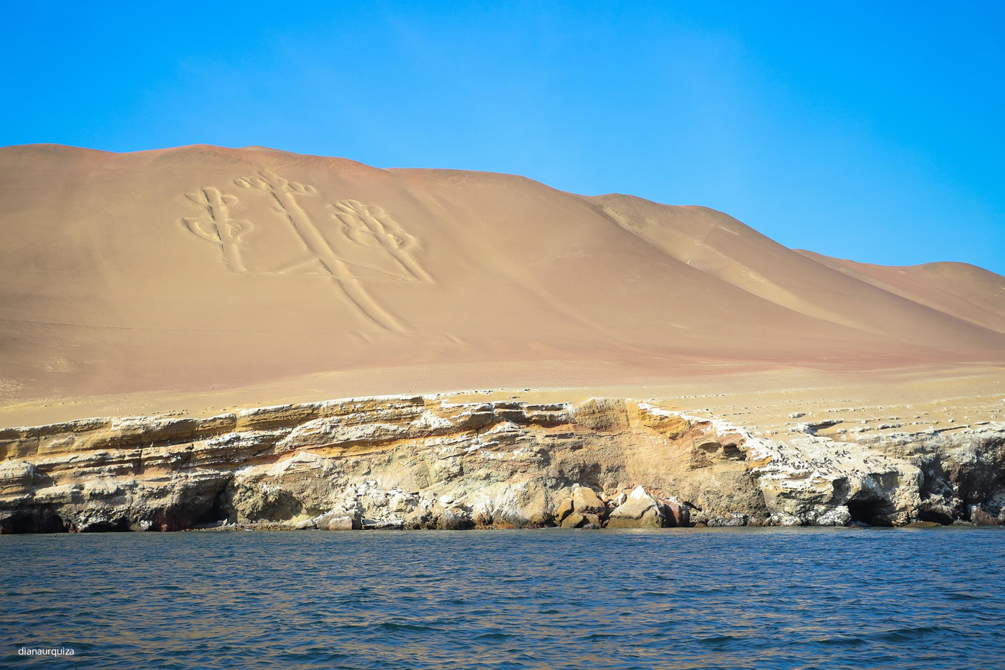 The Paracas Candelabro, a massive geoglyph etched into a sandy hill overlooking the Pacific Ocean in Peru.