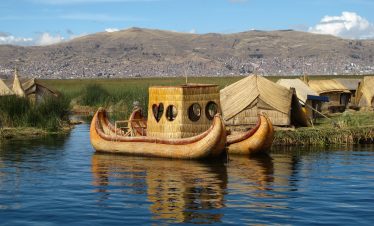 View of Lake Titicaca with traditional reed boats and the Andes in the background