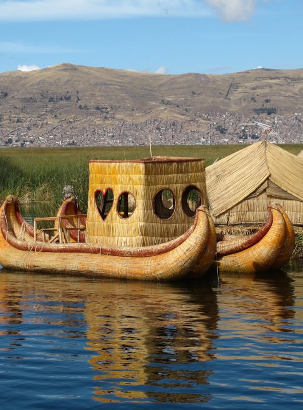 View of Lake Titicaca with traditional reed boats and the Andes in the background