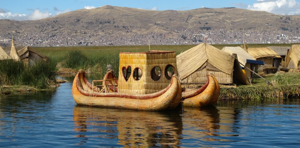 View of Lake Titicaca with traditional reed boats and the Andes in the background