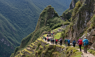 A group of hikers trekking along the scenic Inca Trail, surrounded by lush green mountains and ancient stone terraces.