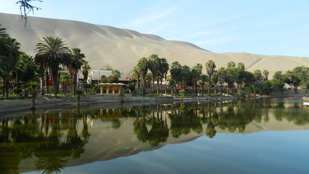 The peaceful lagoon and palm trees of Huacachina oasis in southern Peru.