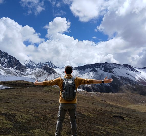 Un viajero en Perú contemplando un majestuoso nevado, conectando profundamente con la energía de la naturaleza.